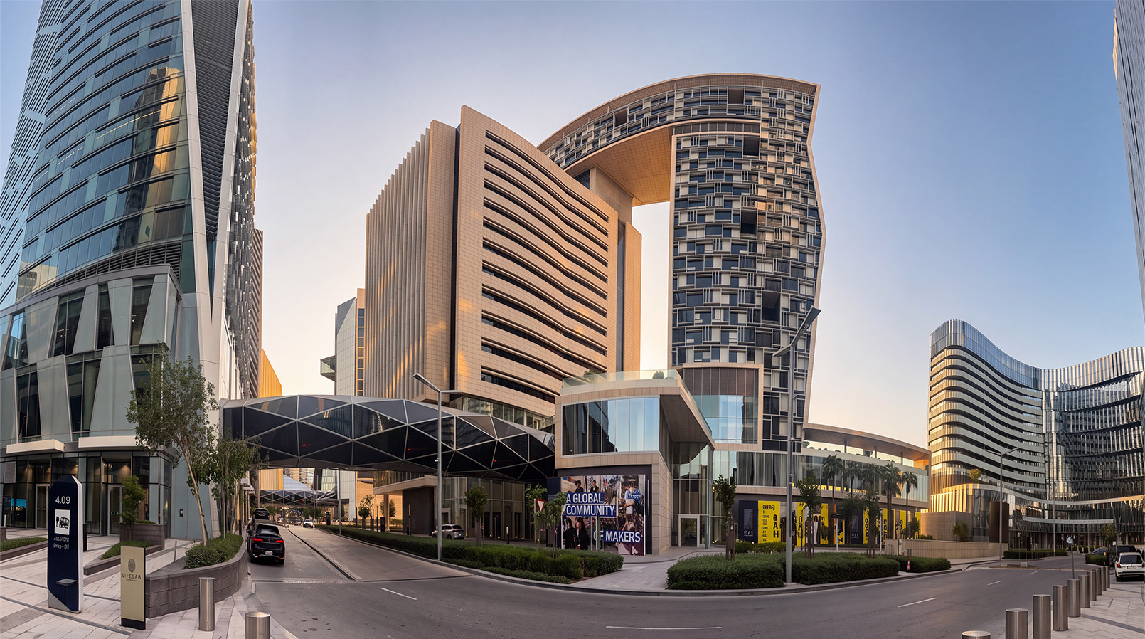 Street-level view of KAFD buildings and an elevated walkway.