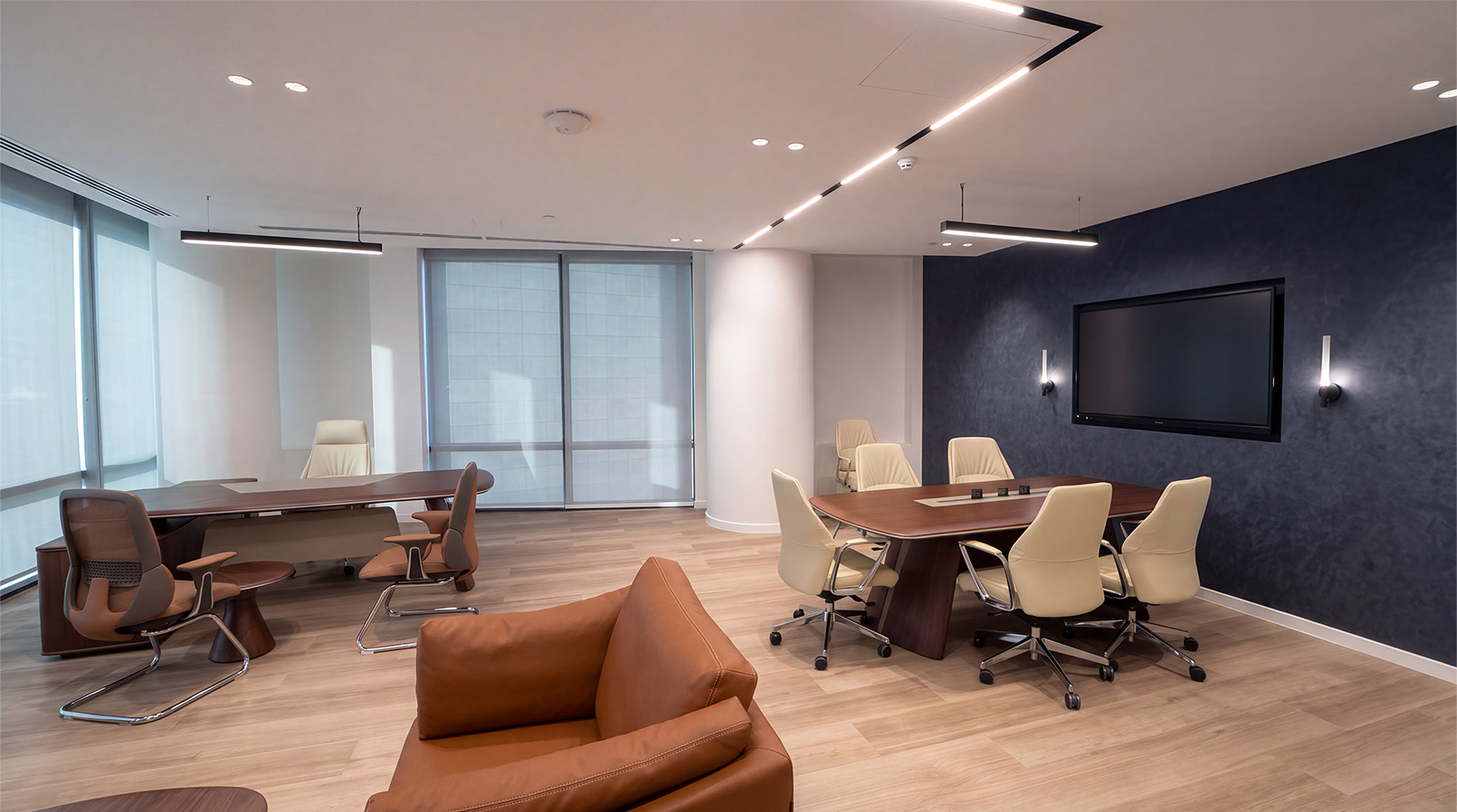 Shared work area with tables, task chairs and a tan sofa.