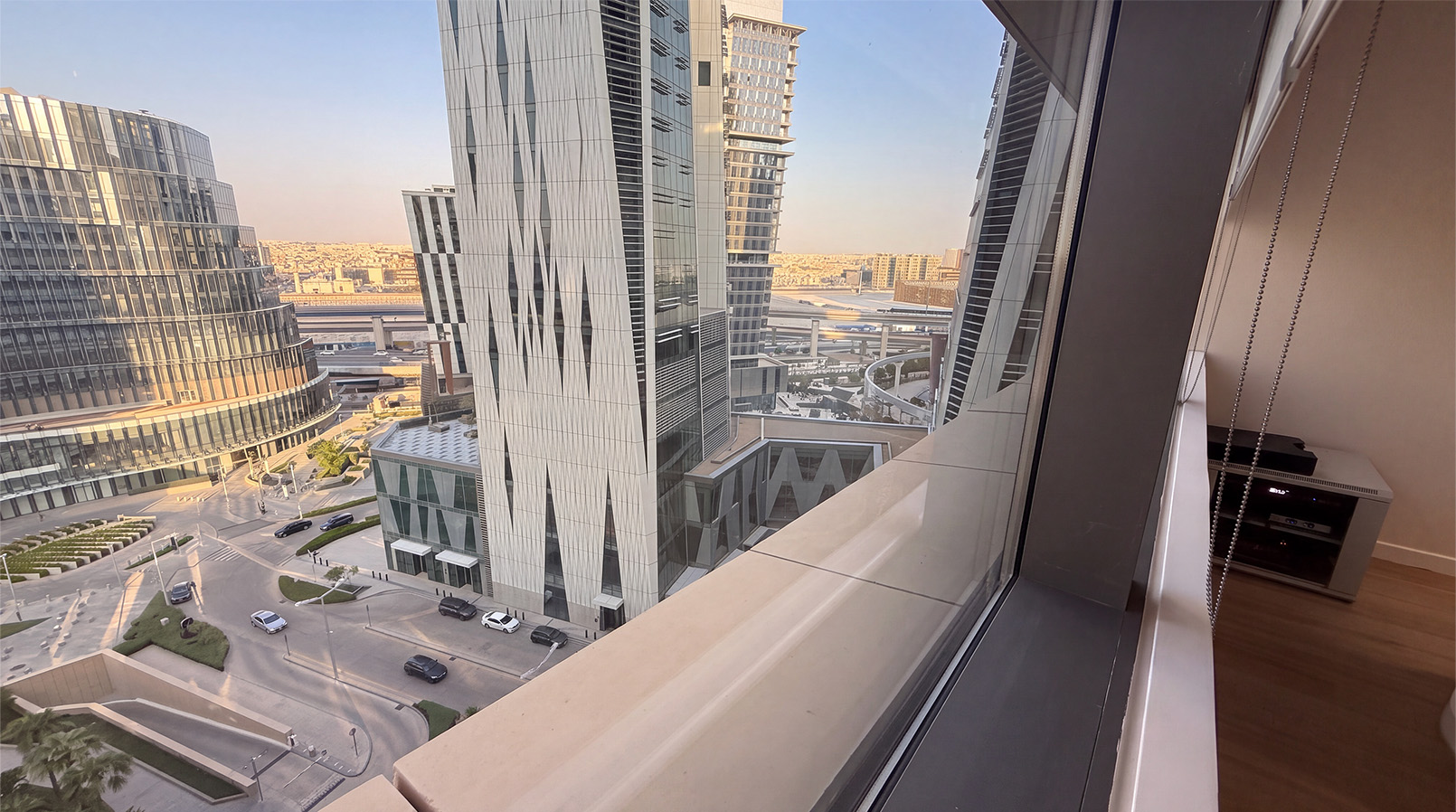 View through campus windows towards nearby KAFD towers and streets.