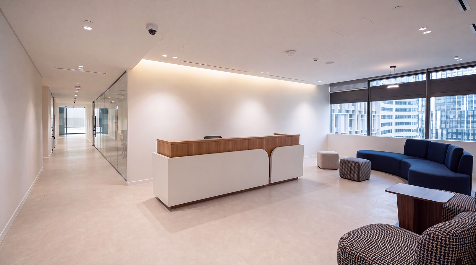 Bright reception area with a white desk and blue seating beside the windows.